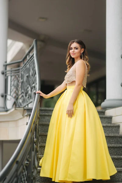 Menina bonita com maquiagem e penteado está de pé nos passos — Fotografia de Stock