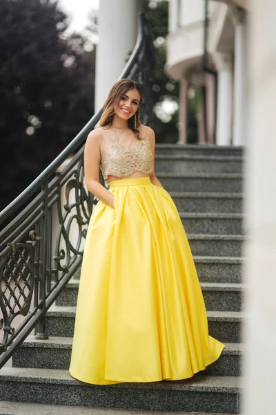Sarı erening elbiseli Bayan ayakta merdivenlerde — Stok fotoğraf