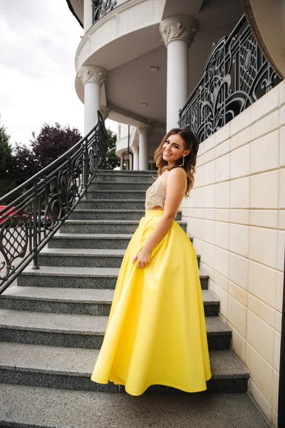 Señora en amarillo erening vestido de pie en las escaleras —  Fotos de Stock