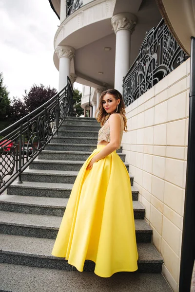 Lady in yellow erening dress stand on stairs — Stock Photo, Image