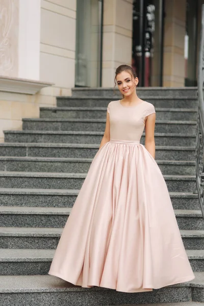 Elegant brunette lady stand on stairs by the hotel — Stock Photo, Image