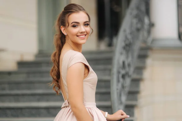 Elegante brünette Dame steht auf der Treppe neben dem Hotel — Stockfoto