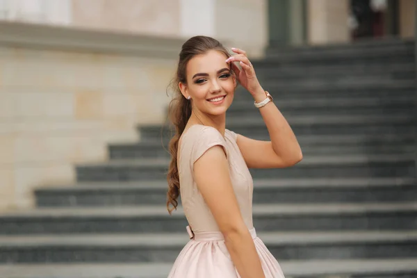 Elegante dama morena parada en las escaleras junto al hotel — Foto de Stock