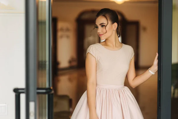 Stilvolles Mädchen im Kleid steht in der Hotelhalle. Mädchen lächeln in die Kamera — Stockfoto