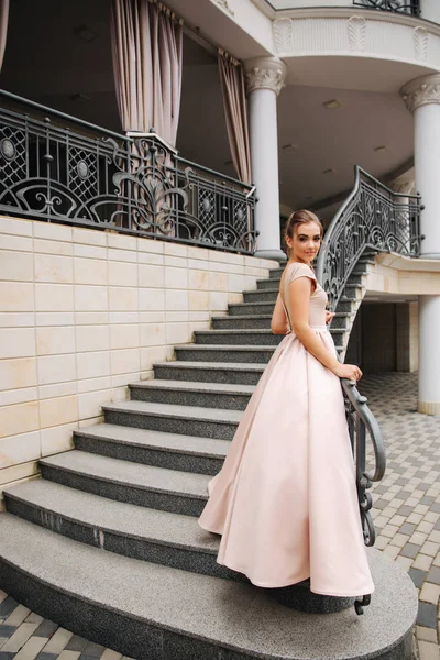 Elegante dame satnd op trappen voor restaurant — Stockfoto