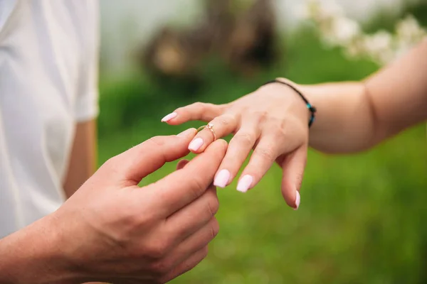 O homem faz um pedido de casamento a uma rapariga. Dá-lhe um anel para o noivado. Mãos fechadas — Fotografia de Stock