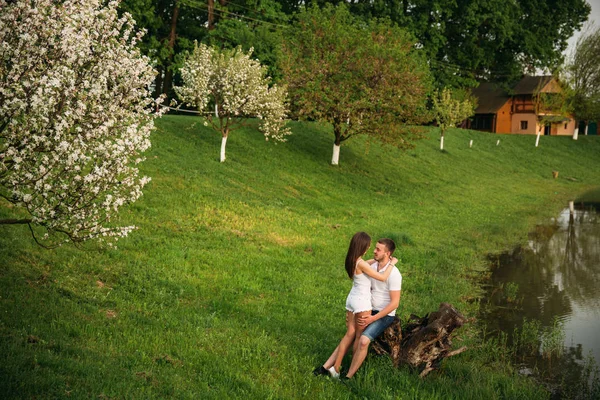 Dating in park. Love couple standing together on grass near the lake. Romance and love