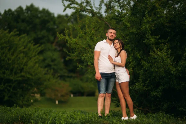 Citas en el parque. Pareja de amor de pie juntos en la hierba cerca del lago. Romance y amor —  Fotos de Stock