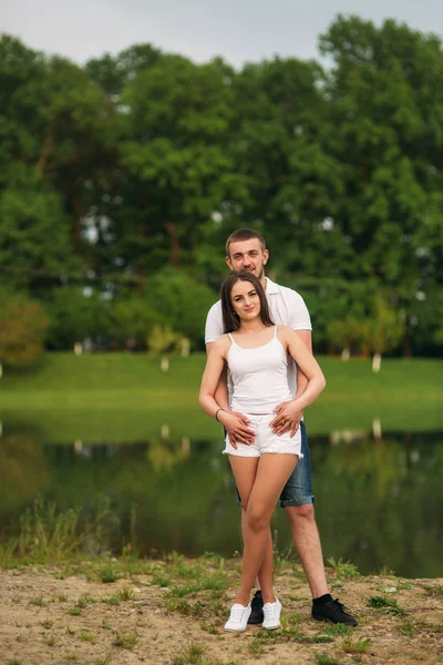 Verliebte Paare umarmen sich in der Nähe des Sees — Stockfoto