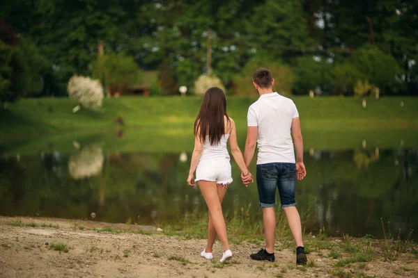 Verliefde paar omhelzen elkaar in de buurt van het meer — Stockfoto