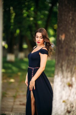 Mavi elbiseli güzel bir kız parkta yürüyor. Güneşli bir gün. Yaz