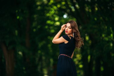 Mavi elbiseli güzel bir kız parkta yürüyor. Güneşli bir gün. Yaz