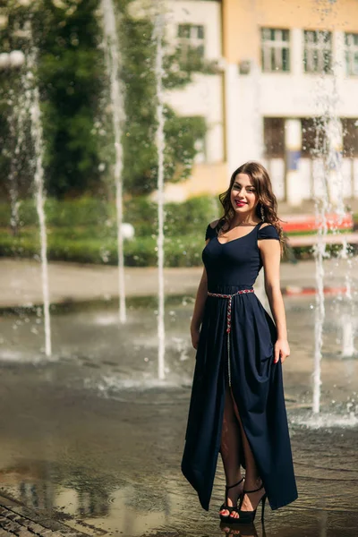 Une fille se promène dans la ville, près d'une grande fontaine. Journée ensoleillée. Été — Photo