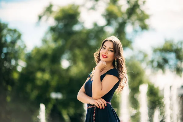 Una chica está caminando por la ciudad, cerca de una gran fuente. Día soleado. Verano — Foto de Stock