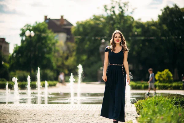 Een meisje loopt rond de stad, in de buurt van een grote fontein. Zonnige dag. Zomer — Stockfoto