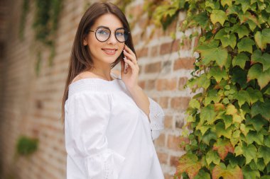 Cep telefonu sokakta konuşurken mutlu genç bayan