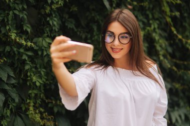 Güzel kız akıllı telefon dışında bir selfie yapmak
