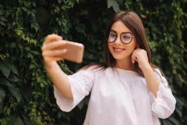 Şehirde yaz kız portre akıllı telefon kullanan mutlu güzel kız