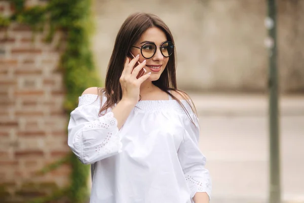 Jovencita feliz hablando por teléfono móvil en la calle — Foto de Stock