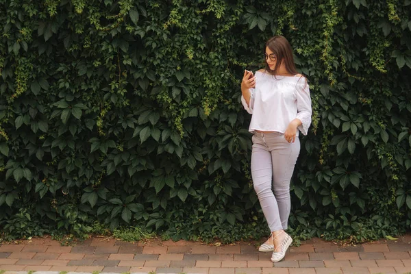 Gelukkig mooi meisje met behulp van slimme telefoon in de stad, zomer meisje portret — Stockfoto