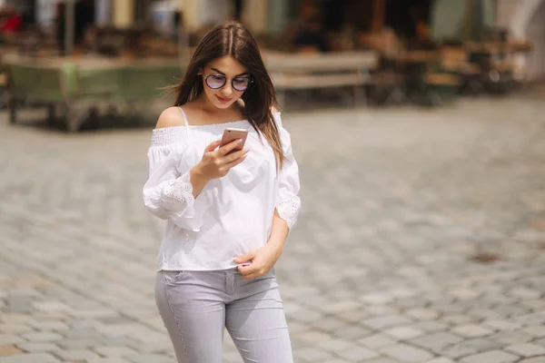 年轻开朗的女人在户外休息时看着智能手机上的滑稽视频 — 图库照片