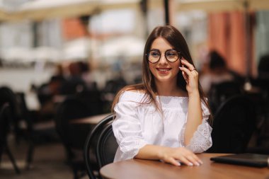 Giden Bayan telefon ve bekleyen garson tarafından portresi. Sokağın peşinde. İş ve dinlenme kavramı