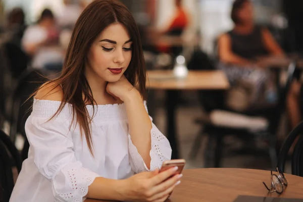 Ung glad kvinna elektronisk bok på smart telefon, i väntan på hennes order — Stockfoto