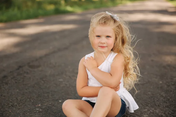 Retrato de una pequeña hija sonriente al aire libre. Cabello rubio niña — Foto de Stock