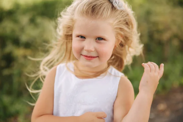 Portret van kleine dochter buitenshuis te glimlachen. Blonde haren meisje — Stockfoto