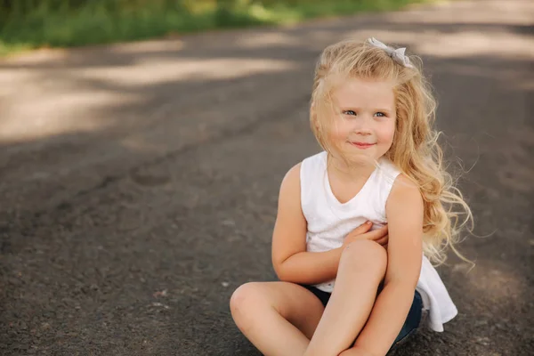 Küçük kızı açık havada gülümseyen portresi. Sarı saçlı küçük bir kız — Stok fotoğraf