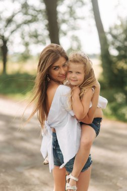 yaz günü gün batımı sırasında parkta annemle oynayan küçük kız