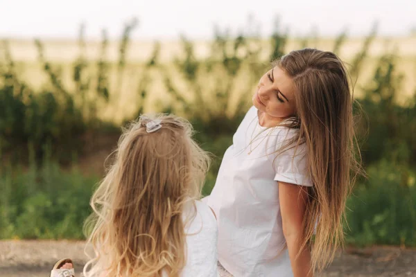 Schöne Mutter und ihr Kind spielen zusammen im Park. Außenporträt einer glücklichen Familie. — Stockfoto