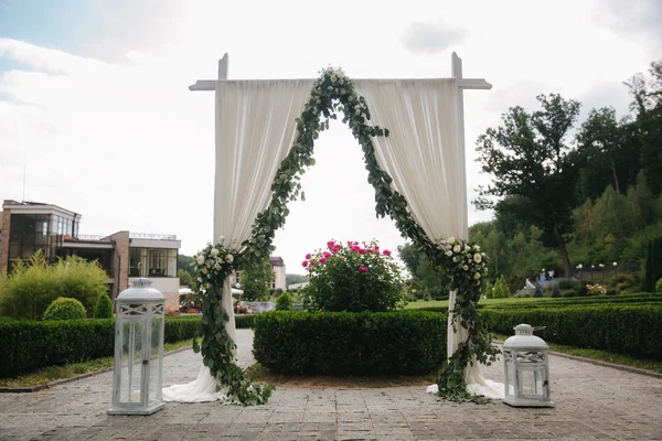 Weddind decoration on open air. Floral decor of a beautiful white arch. Beautiful beckground view of trees — Stock Photo, Image