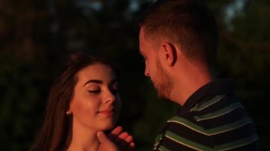 Güneşin battığı sırada güzel çift birbirlerine sarılmak. günbatımı