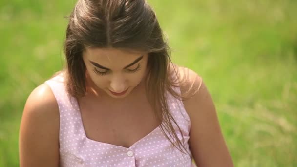 Schöne Dame sitzt auf Gras im Feld — Stockvideo