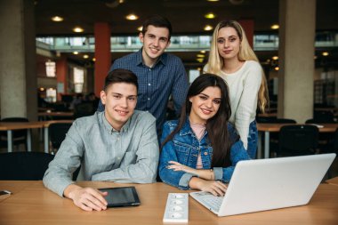 Üniversite öğrencilerinin okul Kütüphanesi, bir kız ve bir erkek eğitim grup olup bir dizüstü bilgisayar kullanarak Internet'e bağlanma