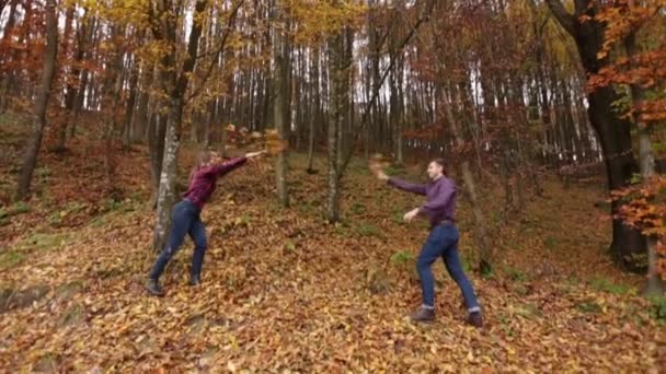 Ein liebendes Paar wirft sich Blätter zu. Herbststimmung. Zeitlupe — Stockvideo