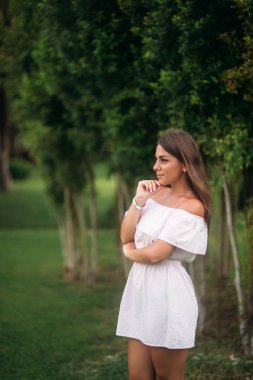 Genç ve güzel kız ağacın yakınındaki bir yaz şehir ayakta