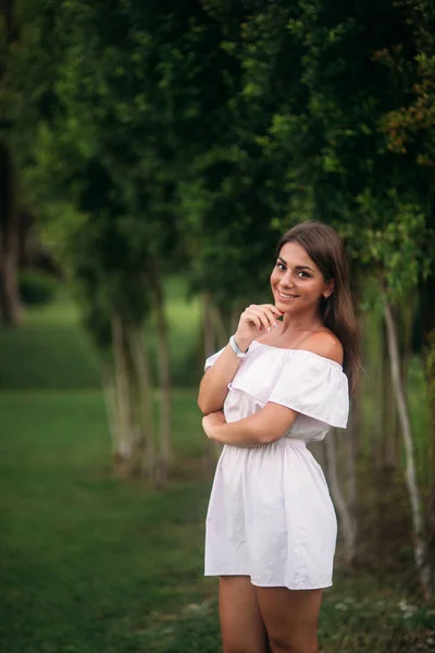 Молода і красива дівчина в літньому місті, що стоїть біля дерева — стокове фото