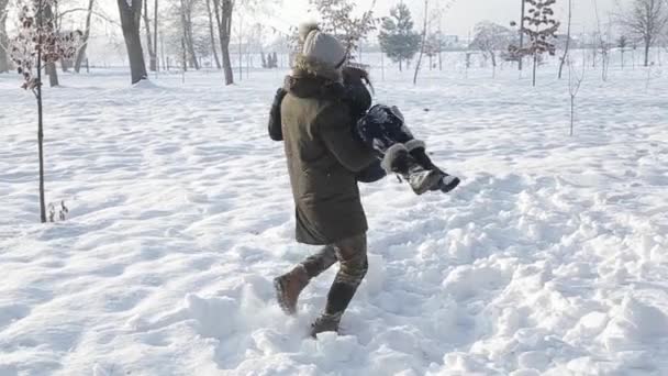 Gelukkige paar spelen samen tijdens de winter vakantie roeping buiten in de sneeuw park — Stockvideo