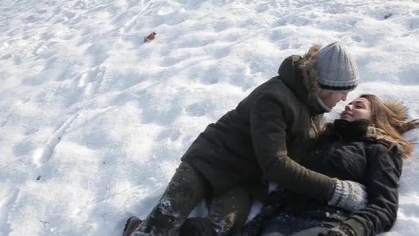 Feliz pareja juegan juntos durante las vacaciones de invierno vocación al aire libre en el parque de nieve — Vídeos de Stock
