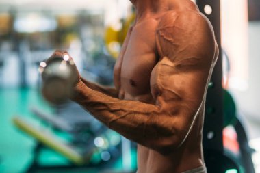 Genç bir atlet spor salonunda eğitiyor. Trians pazı muscules