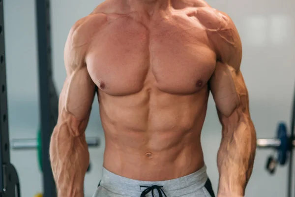 Um jovem atleta treina no ginásio. Trians bíceps músculos — Fotografia de Stock