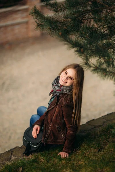 Krásná dívka chodí po nábřeží. Blond vlasy a hnědé sako. Jaro — Stock fotografie