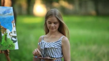 Park ve holding palet boya ile dışkı üzerinde güzel kız sanatçıdır