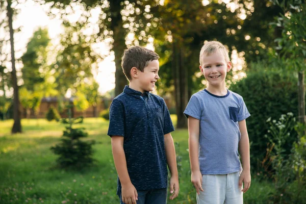 Due bambini amici ragazzi che passeggiano nel parco in una giornata estiva soleggiata — Foto Stock