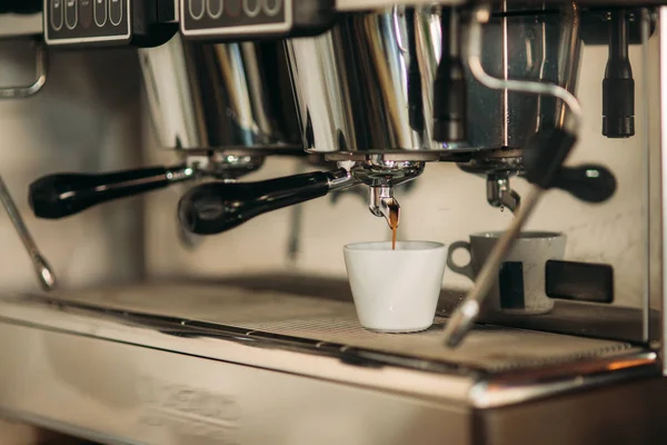 Professional coffee machine making espresso in cafe