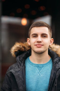 Gri ceketli adamı sokakta duran ve bir fotoğrafçı için poz