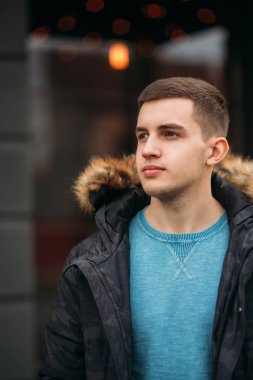 Gri ceketli adamı sokakta duran ve bir fotoğrafçı için poz