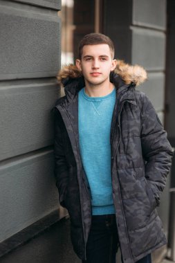 Gri ceketli adamı sokakta duran ve bir fotoğrafçı için poz
